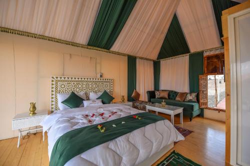 a bedroom with a large bed and a couch at Agafay Pearl Camp Marrakech in Marrakech