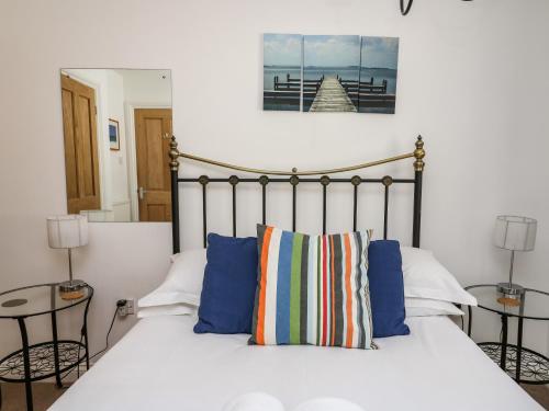 ein Schlafzimmer mit einem weißen Bett mit blauen Kissen in der Unterkunft Ty'r Heulwen in Aberdyfi