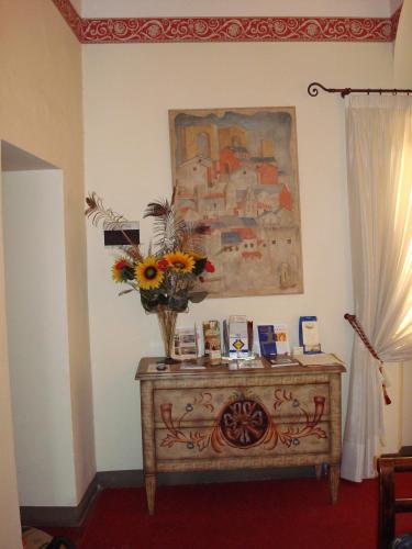 a room with a table with a vase of flowers on it at Soggiorno Dimora Del Grifo in San Miniato