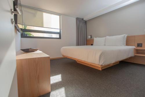 a bedroom with a large bed and a window at V65 Mx in Mexico City