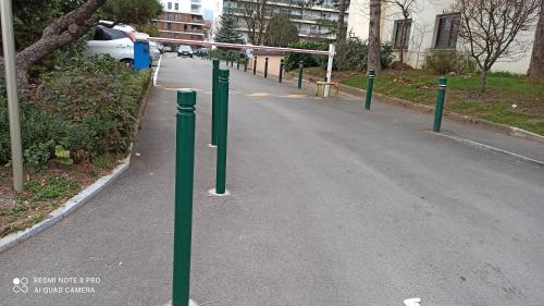 a row of green poles in the middle of a road at M & L in Ambilly
