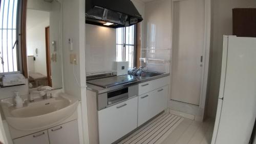 una gran cocina blanca con fregadero y fregadero en Guest House Mulberry - Vacation STAY 9580, en Kirishima