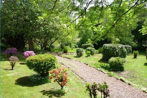 a gravel path in a garden with bushes and trees at Buchanan Arms Hotel & Leisure, Sure Hotel Collection in Drymen
