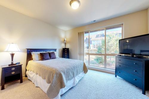 um quarto com uma cama e uma grande janela em Eagle Crest Creekside Escape em Redmond