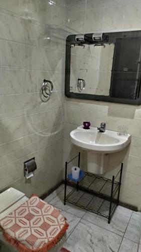 y baño con lavabo y espejo. en Arraial do Cabo - suite, en Arraial do Cabo