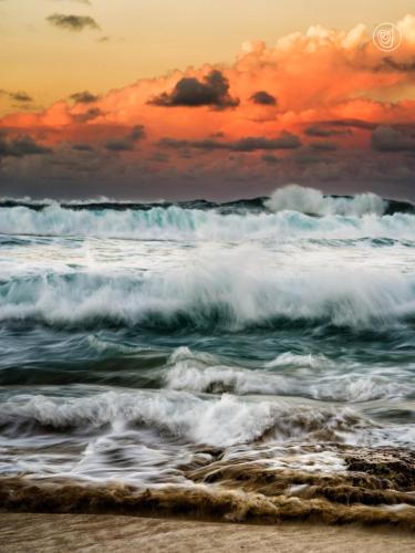 a beach with crashing waves and a sunset at Residencial Mañanero in Cabarete