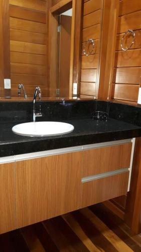 a bathroom with a sink with a black counter top at Linda casa 3 quartos Castelhanos ES in Anchieta