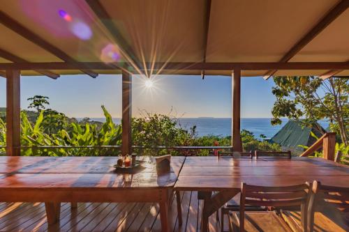 a wooden table on a deck with a view of the ocean at Punta Marenco Lodge in Drake