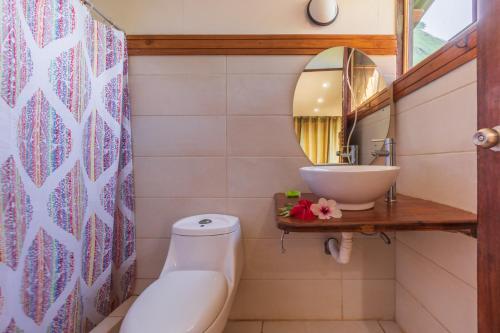 uma casa de banho com um lavatório, um WC e um espelho. em Punta Marenco Lodge em Drake