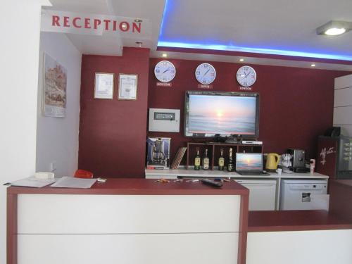 un magasin avec des horloges sur le mur et un comptoir de réception dans l'établissement Family Hotel Magnolia, à Balchik