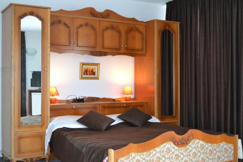 a bedroom with a large bed with a wooden canopy at Family Hotel Magnolia in Balchik