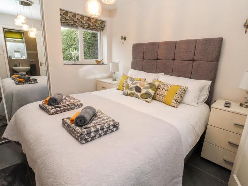 a bedroom with a large bed with two towels on it at The Old Stable in Penyffordd