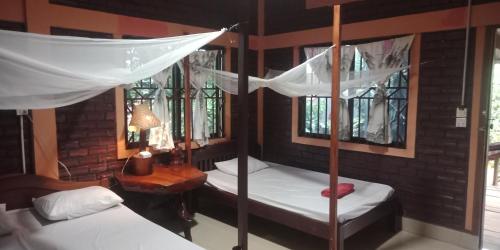 a bedroom with two bunk beds and a table with a lamp at FamilyHouse & Trekking in Banlung