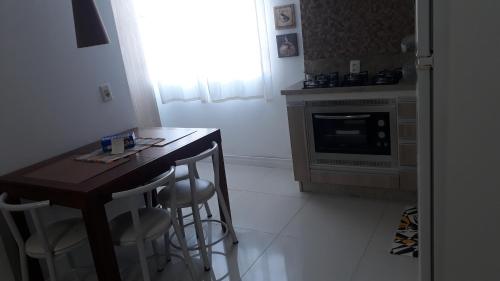 a kitchen with a wooden table and a stove at Apartamento 5 min do Consulado Americano Porto Alegre in Porto Alegre