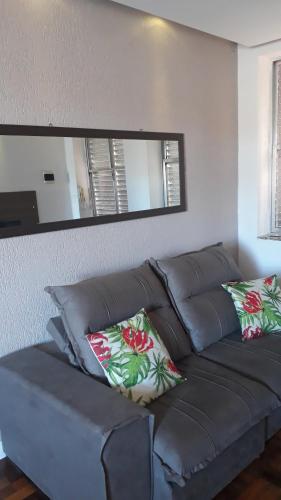 a brown couch in a living room with a mirror at Apartamento 5 min do Consulado Americano Porto Alegre in Porto Alegre