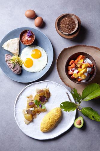 a table with plates of breakfast foods and eggs at The Spa Resorts - Lamai Beach in Lamai