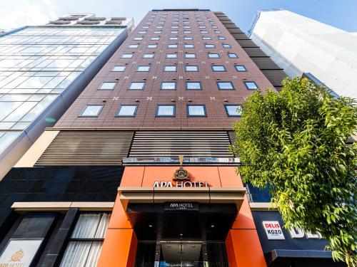 a tall building with an amazon hotel sign on it at APA Hotel Mita Ekimae in Tokyo