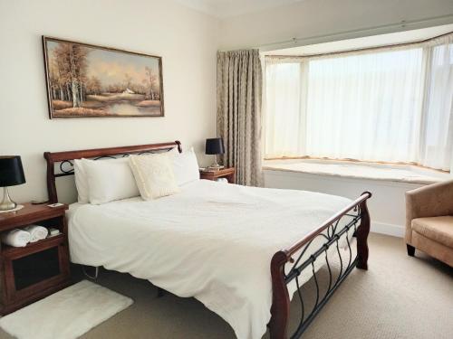 Un dormitorio con una cama grande y una ventana en Ocean Aspect and Central to CBD - CoSheirm Apartments On Merri, en Warrnambool