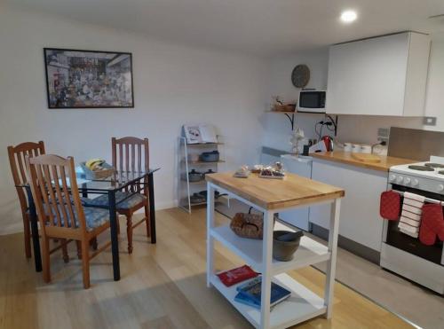 een keuken met een tafel en een tafel en stoelen bij Beautiful 1 bedroom cottage on 1 acre in Sandford