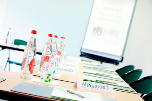 a table with bottles and a computer on it at Campanile Montluçon ~ Saint-Victor in Saint-Victor