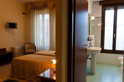 Habitación de hotel con cama y lavabo en Mediterraneo, en Pianoro