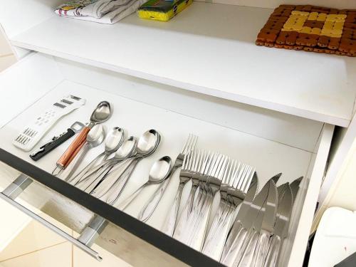 un cassetto pieno di utensili argentati di Eu Amo Arraial Hospedagem - Prainha 3 Quartos com Ar condicionado ad Arraial do Cabo
