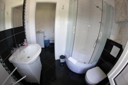 a bathroom with a sink and a shower and a toilet at Palace Inn Rooms in Split