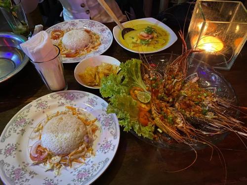 a table topped with plates of food and a salad at Relax Beach House in Tangalle
