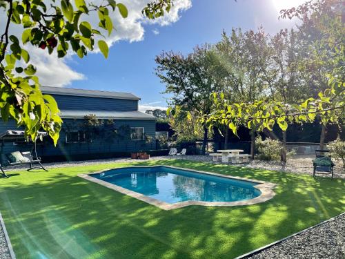 a swimming pool in a yard with green grass at Farm Stay POPLAR Cottage at Wilindi Estate in Tyabb