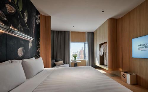 a hotel room with a bed and a flat screen tv at PARKROYAL COLLECTION Kuala Lumpur in Kuala Lumpur