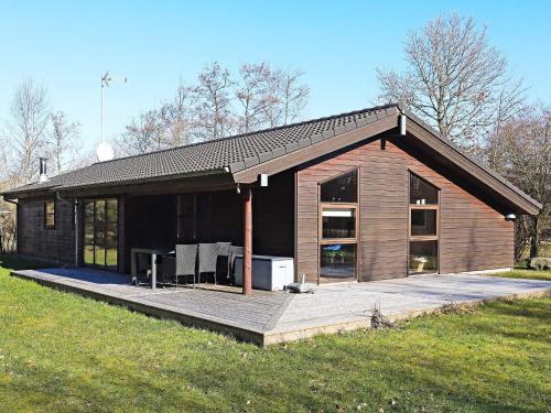 een klein huis met een terras in een veld bij 8 person holiday home in Fjerritslev in Torup Strand