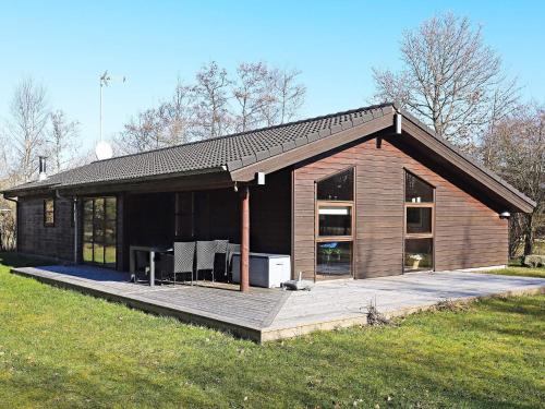 a small house with a deck in a field at 8 person holiday home in Fjerritslev in Torup Strand