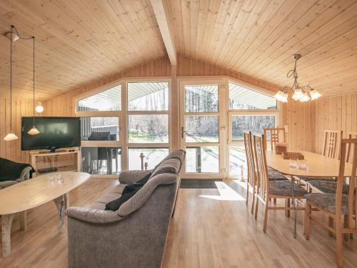 een woonkamer met een bank en een tafel en stoelen bij 6 person holiday home in Fjerritslev in Fjerritslev