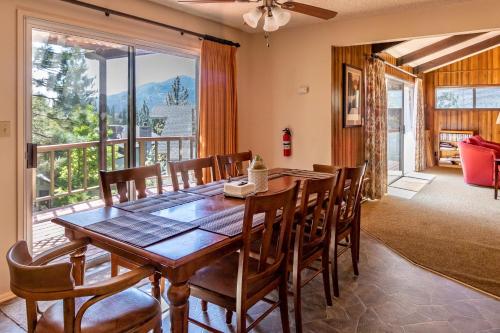 a dining room with a table and chairs and a balcony at Miglin Lakeview in Bass Lake