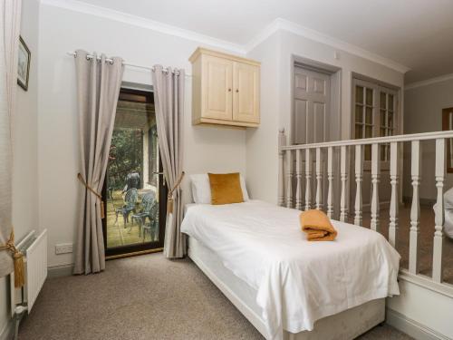 Un dormitorio con una cama blanca y una escalera. en The Skilling, en Bridport
