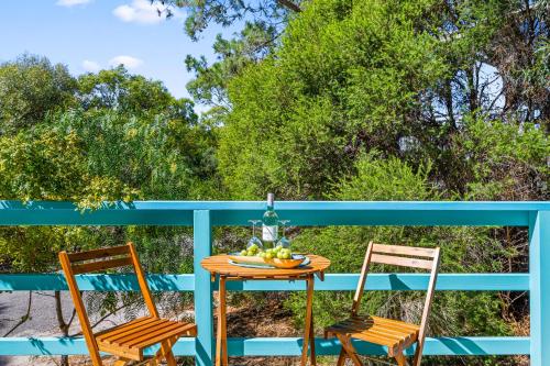 two chairs and a table with a bowl of fruit at Casa Capri - Aldinga Beach - C21 SouthCoast Holidays in Aldinga Beach