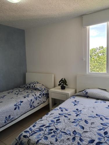 a bedroom with two beds and a window at 3Rooms Amaizing Beach Studio in Jacó