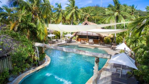 an aerial view of a resort pool with palm trees at Castaway Island, Fiji in Castaway Island