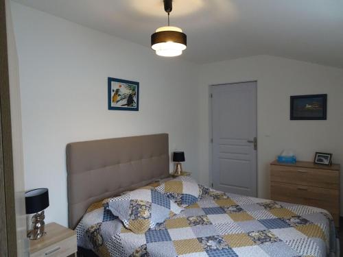 a bedroom with a bed with a quilt on it at Pretty cottage near sandy beach in the Cotentin in Gouville-sur-Mer