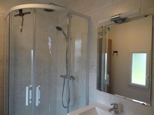 uma casa de banho com um chuveiro, um lavatório e um espelho. em Pretty cottage near sandy beach in the Cotentin em Gouville-sur-Mer