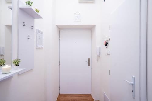 a white bathroom with a door in a room at FAMILY Apartment OSTRAVA in Ostrava
