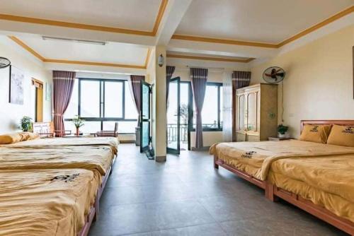 a hotel room with two beds and windows at Villa Kien Hanh Tam Dao - Venuestay in Vĩnh Phúc
