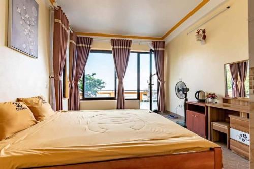 a bedroom with a large bed with a large window at Villa Kien Hanh Tam Dao - Venuestay in Vĩnh Phúc