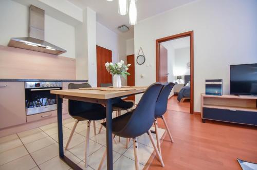 a kitchen and dining room with a table and chairs at Apartamenty Na Wyspie - Baltic Park - Apartamenty z sypialnią i parkingiem - ul Uzdrowiskowa 24-34 in Świnoujście
