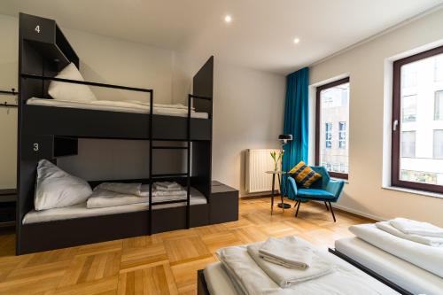 a bedroom with two bunk beds and a chair at Henriettas Sleeping in Ulm