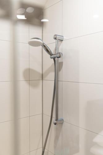 a shower with a shower head in a bathroom at Henriettas Sleeping in Ulm