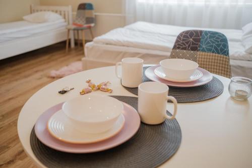 a table with two cups and plates on top of it at Kastanimaja Apartments in Tartu