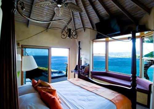 a bedroom with a bed with a view of the ocean at Maca Bana in Saint Georgeʼs