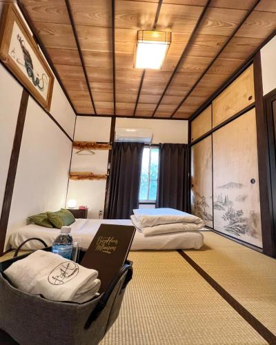 a room with two beds and a table in it at Bighem Maison in Izumi-Sano