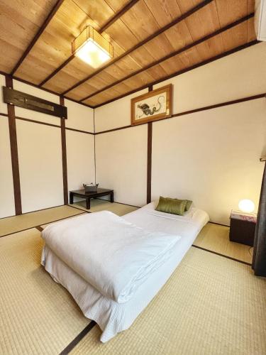 a bedroom with a large white bed in a room at Bighem Maison in Izumi-Sano
